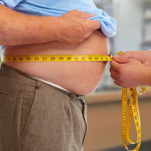 Measuring abdominal belly fat with measuring tape for weight loss guide