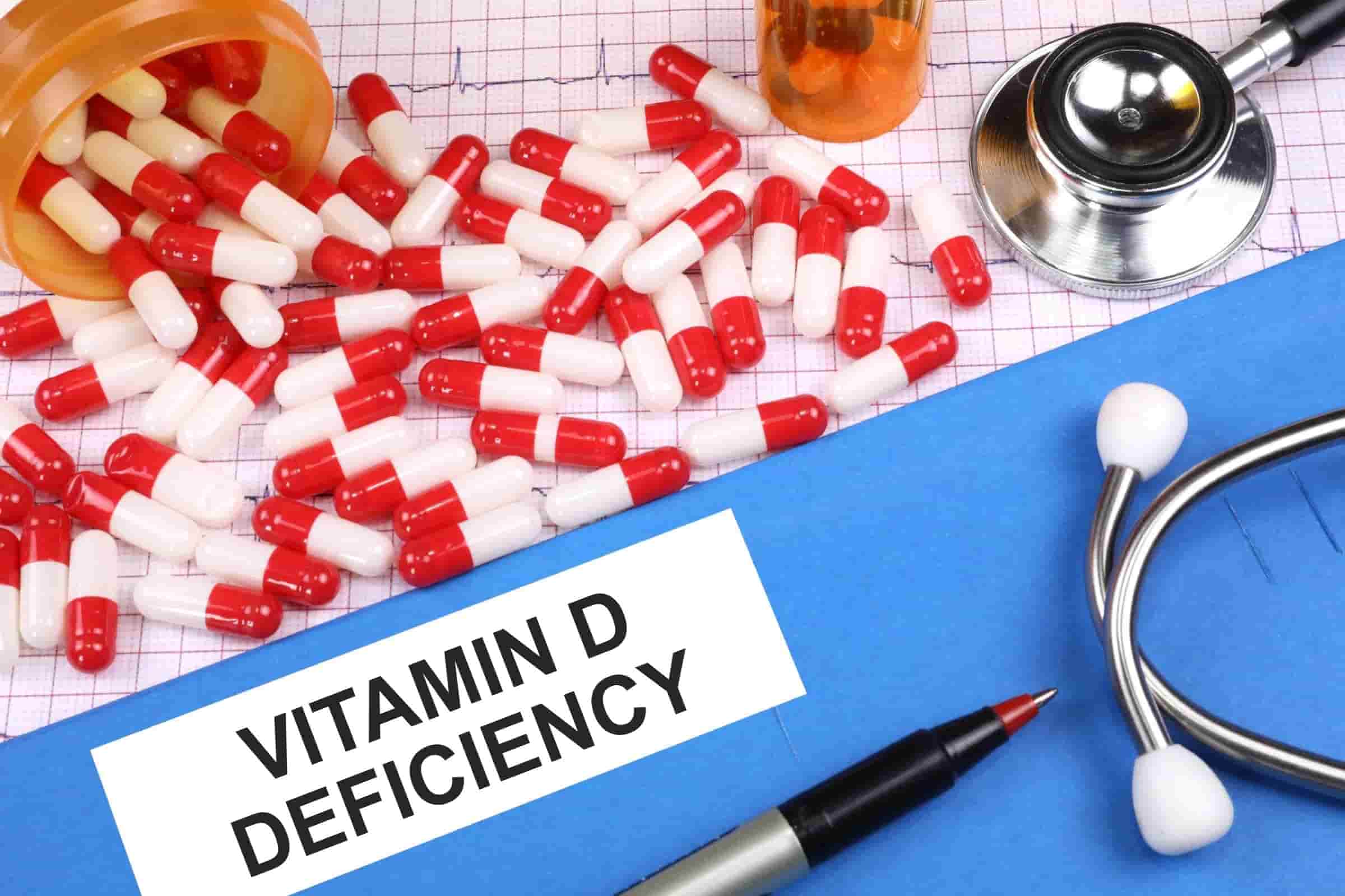 Stethoscope forming a heart shape around a Vitamin D capsule with 'VITAMIN D DEFICIENCY' text